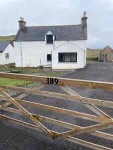 a gate in front of a white house at Oldshorecroft in Sheigra