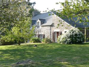 a dog sitting in the grass in front of a house at cancaleloca in Cancale