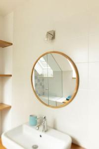 La salle de bains est pourvue d'un miroir au-dessus d'un lavabo. dans l'établissement cancaleloca, à Cancale 77 autres photos