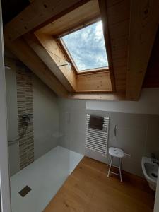 a bathroom with a skylight and a shower and a sink at Casa delle Orchidee in Feltre