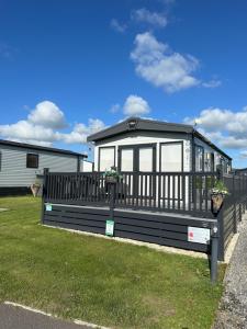 a small house with a black fence and grass at Duckpool 108 Bude in Bude +40 photos