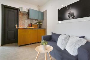 a living room with a blue couch and a kitchen at Acogedor estudio en la laguna in La Laguna +22 photos