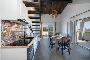 a kitchen and dining room with a table and chairs at Pecora Nera apartments in Lixouri