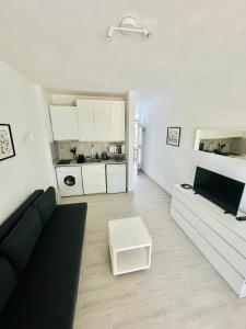 ein Wohnzimmer mit einer schwarzen Couch und einer Küche in der Unterkunft Apartamento Eureka Costa Del Silencio in Costa Del Silencio