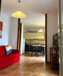 a living room with a red couch and a kitchen at BELLAVISTA Charme & Relax in Bergamo