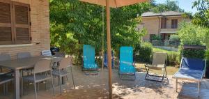 a patio with a table and chairs and an umbrella at La Casa delle Ciliegie in Assisi