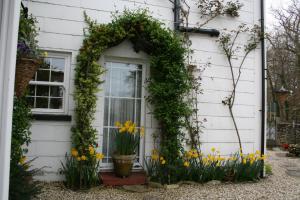 una puerta de entrada de una casa con una corona y flores en Clayhill House Bed & Breakfast en Lyndhurst
