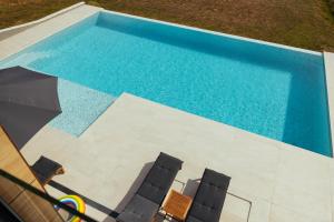 an overhead view of a pool with chairs and an umbrella at Vila Pogled in Vrdnik