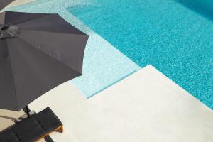 a black umbrella sitting next to a swimming pool at Vila Pogled in Vrdnik