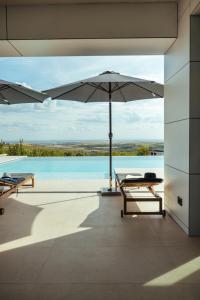an open patio with an umbrella and a body of water at Vila Pogled in Vrdnik