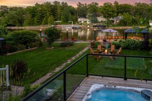 a view of a backyard with a hot tub at Charming riverside cottage, walk to beach in Wasaga Beach