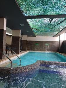 een groot zwembad in een gebouw met een groot plafond bij Golden View Zlatibor in Zlatibor