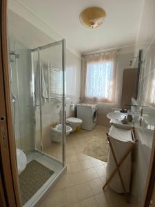 a bathroom with a shower and two sinks and a toilet at Easy Access to Venice Apartment in Marcon