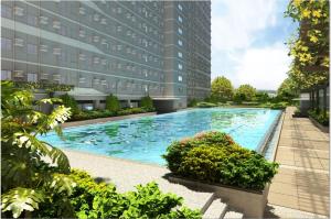 a large swimming pool in front of a building at HabbsVille at Green 2 Residences by SMDC Dasmarinas Cavite in Dasmariñas