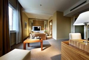 a living room with a table and a television at Hotel Saint John in Rome