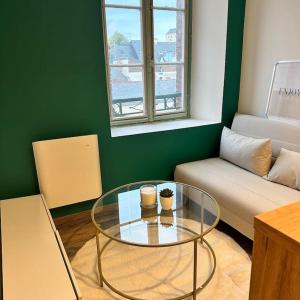 a living room with a glass table and a couch at Joli appartement neuf au centre de Rennes in Rennes
