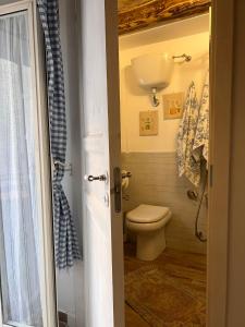 a bathroom with a toilet and a sink at La casetta di Vale in Marano Equo +6 photos