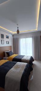 a bedroom with three beds and a window at La Maison Attawba in Beni Mellal