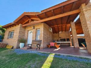 a large brick house with a wooden roof at Cabañas La Cumbre Palermo in La Cumbre