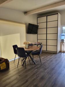a dining room with a table and chairs and a tv at River Apartment in Līči
