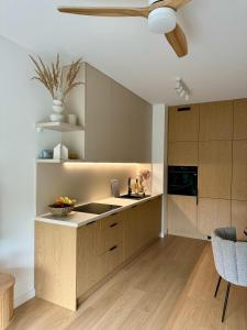 a kitchen with wooden cabinets and a ceiling at Apartament Premium No 5 - Faktura VAT - Targi Kielce - Parking - Blisko Terenów Zielonych - NEW in Kielce +30 photos