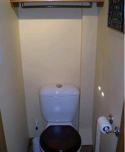 a small bathroom with a toilet with a black seat at Clearview Station & Caboose B&B in Creemore