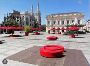 una calle con asientos rojos en medio de una ciudad en Studio NOTRE-DAME 3 cœur de ville, en Cholet 1 foto más