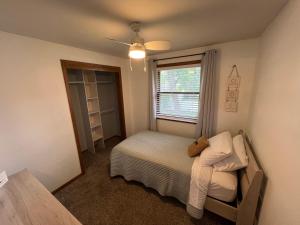 a small bedroom with a bed and a window at Curly's Quarters (4 Bedroom Home) w/ Lambeau view in Green Bay