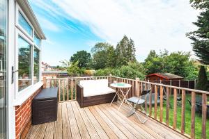 eine Terrasse mit Tisch und Stühlen auf einem Balkon in der Unterkunft Family Gathering Bungalow in Southampton