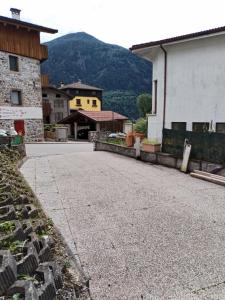 una calle vacía en un pueblo con una montaña en Lûc dal Aur, en Sutrio