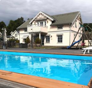 a house with a swimming pool in front of a house at RosaVillan in Kolmården