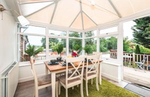 ein Wintergarten-Esszimmer mit einem Tisch und Stühlen in der Unterkunft Family Gathering Bungalow in Southampton