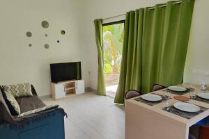 a living room with a table and a television at Fare Hanihei in Uturoa