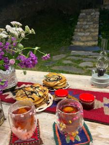 a table with cookies and glasses of tea on it at Ushguli 12 CENTURY in Ushguli