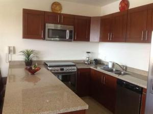 eine Küche mit Holzschränken und einer Arbeitsplatte in der Unterkunft GAVIAS GRANd in La Florida