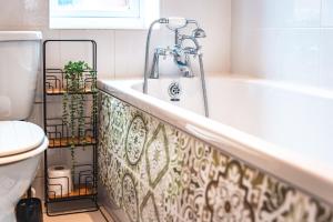 ein Badezimmer mit Badewanne und Toilette in der Unterkunft Family Gathering Bungalow in Southampton + 46 Fotos