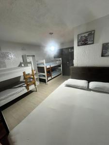 a room with two beds and a room with two bunk beds at Pousada Três Corações in Penha