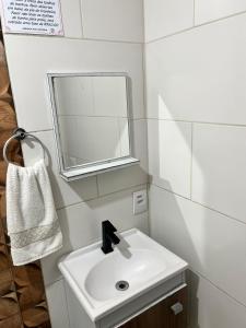 a bathroom with a white sink and a mirror at Pousada Três Corações in Penha +29 photos