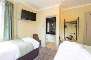 a hotel room with two beds and a bathroom at The Fox Inn in Guisborough