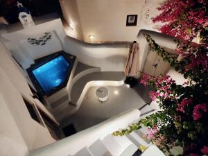 an overhead view of a staircase with a television and flowers at Aidos Villa Santorini in Megalokhori