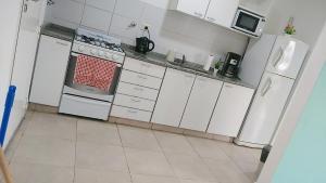 a kitchen with white appliances and white cabinets at Casa Fiorella in Ezeiza +5 photos