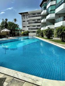 a large swimming pool in front of a building at Porto de Galinhas - Apartamento 3 quartos a 30m do mar in Porto De Galinhas