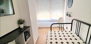 Una pequeña habitación con una cama y una ventana. en Apartment in the center of Alicante, en Alicante