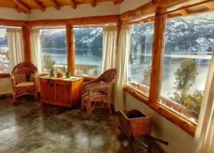 a room with large windows and a table and chairs at Cabañas El Muelle in Cholila +28 photos