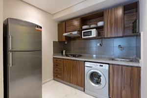 a kitchen with a refrigerator and a washing machine at Luxury One Bedroom - City Center 3 in Rabat