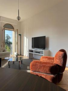 un soggiorno con una sedia arancione e una TV di Tofane sky loft a Treviso