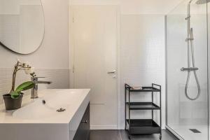 un bagno bianco con lavandino e doccia di Tofane sky loft a Treviso Altre 18 foto