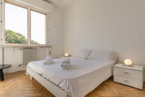 una camera da letto con un letto bianco con due asciugamani sopra di Tofane sky loft a Treviso