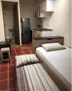 a small kitchen with two beds in a room at Apartaestudios contiguos cerca al Centro Comercial Fabricato in Bello