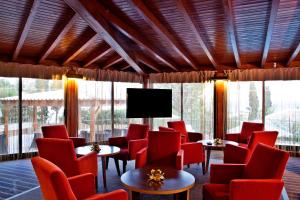a waiting room with red chairs and a flat screen tv at Sao Rafael Holidays in Albufeira